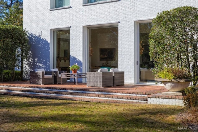 entrance to property with an outdoor living space and a yard