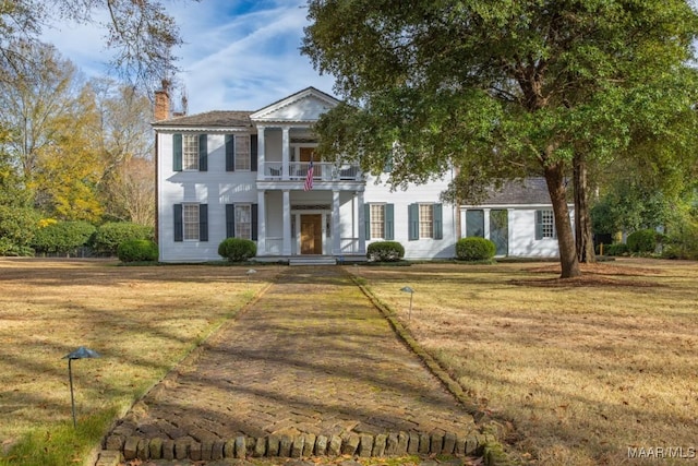 view of front of home with a balcony and a front lawn