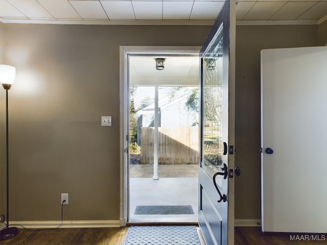 doorway to outside with crown molding and dark hardwood / wood-style floors