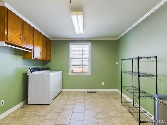 washroom featuring cabinets, ornamental molding, and washer and dryer