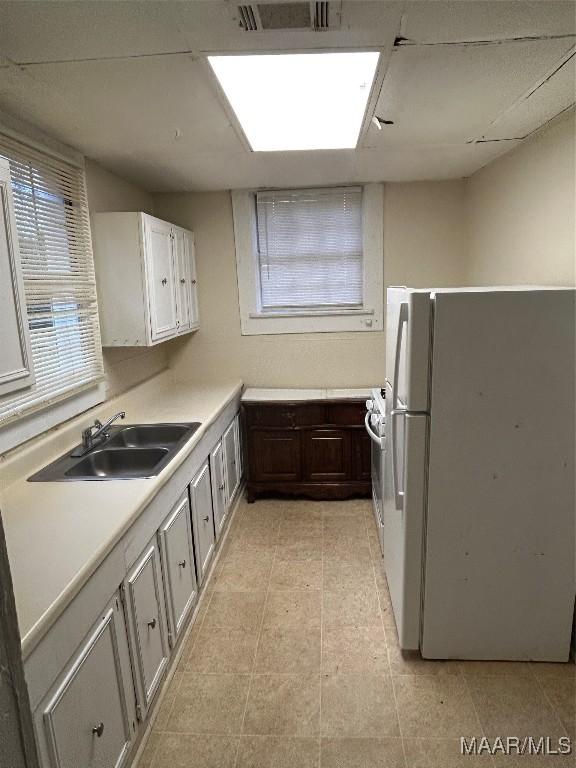 kitchen featuring white cabinetry, sink, plenty of natural light, and white refrigerator