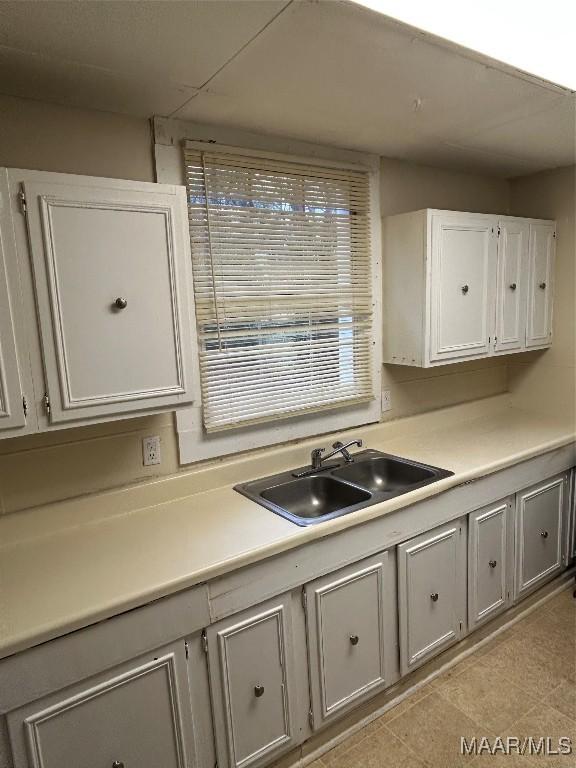 kitchen featuring white cabinetry and sink