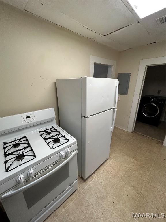 kitchen featuring white appliances, washer / clothes dryer, electric panel, and a drop ceiling