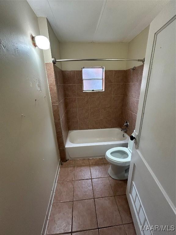 bathroom featuring tile patterned floors, toilet, and tiled shower / bath combo