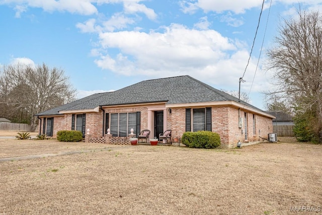 ranch-style home featuring cooling unit and a front yard