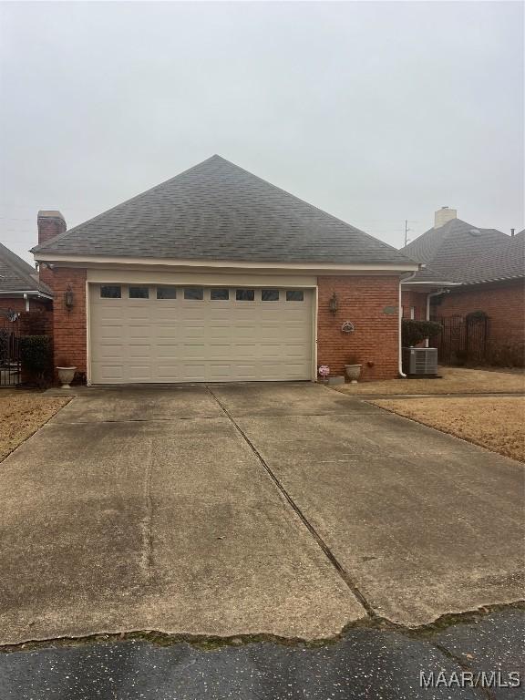 ranch-style home with a garage and central AC