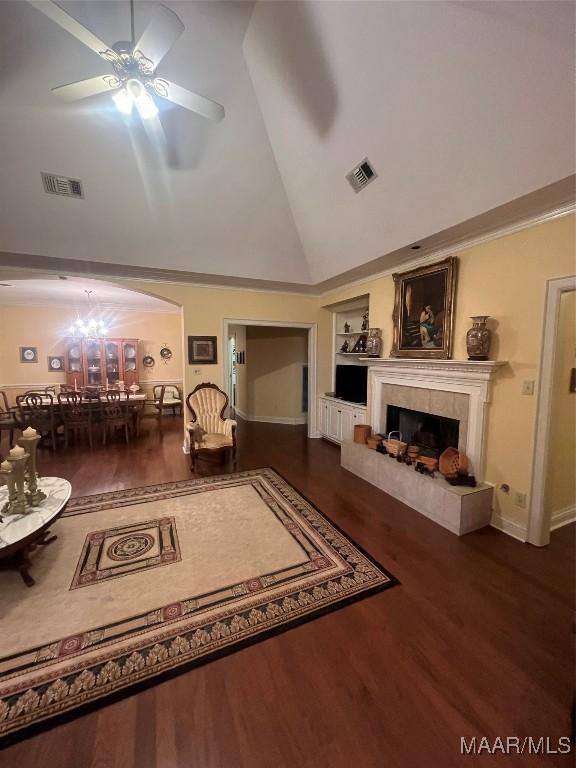 living room with built in shelves, high vaulted ceiling, hardwood / wood-style flooring, ceiling fan, and a fireplace