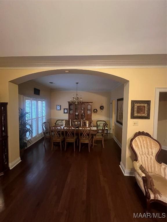 dining space with an inviting chandelier, ornamental molding, and dark hardwood / wood-style floors