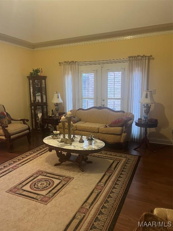 living room with dark wood-type flooring and ornamental molding