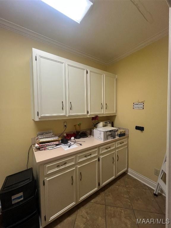 clothes washing area featuring dark tile patterned floors and crown molding