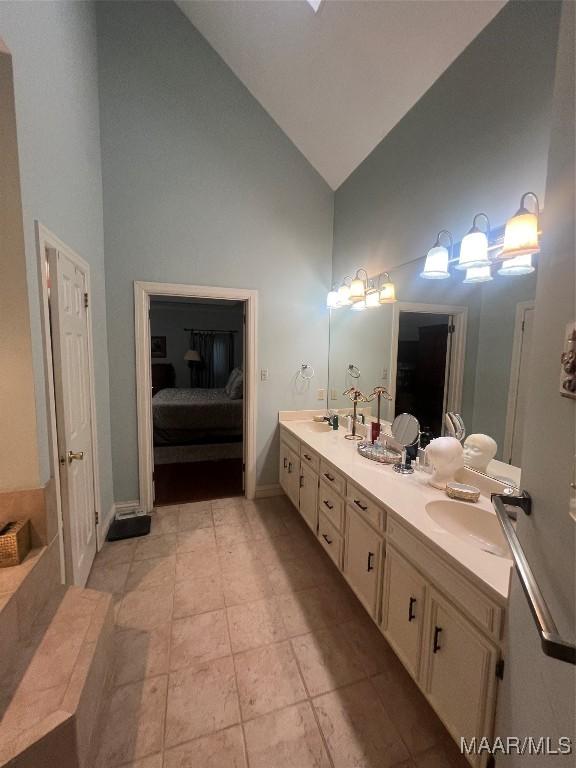 bathroom featuring vanity, tile patterned floors, and high vaulted ceiling