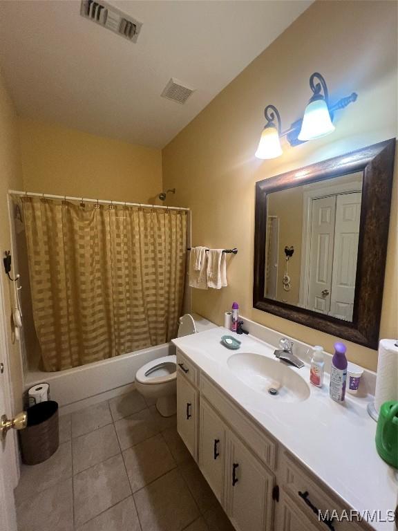 full bathroom with vanity, shower / bathtub combination with curtain, tile patterned floors, and toilet