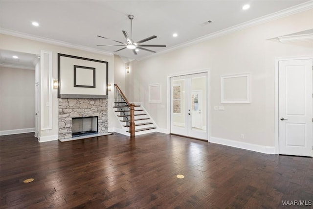 unfurnished living room with crown molding, a stone fireplace, dark hardwood / wood-style floors, and ceiling fan