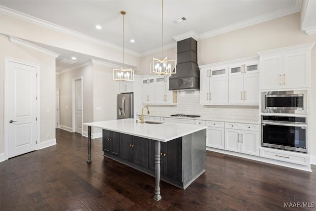 kitchen featuring premium range hood, pendant lighting, an island with sink, white cabinets, and stainless steel appliances