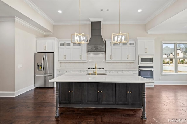 kitchen with pendant lighting, stainless steel appliances, a kitchen island with sink, and custom exhaust hood