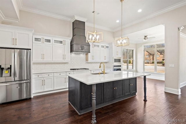 kitchen featuring premium range hood, white cabinetry, sink, a kitchen island with sink, and stainless steel appliances