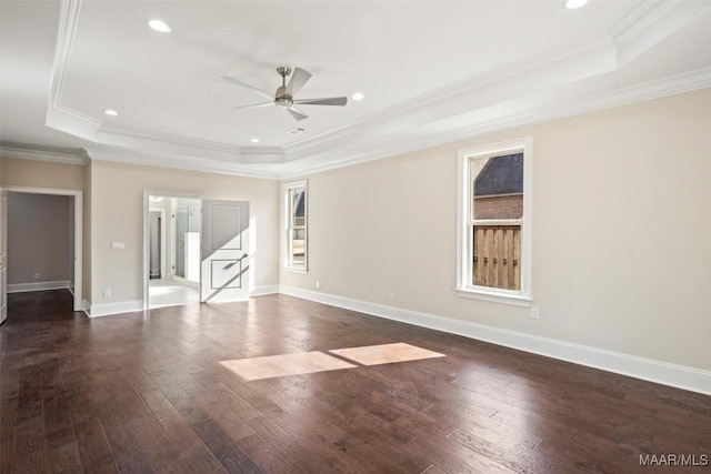 spare room featuring dark hardwood / wood-style flooring, a tray ceiling, crown molding, and ceiling fan