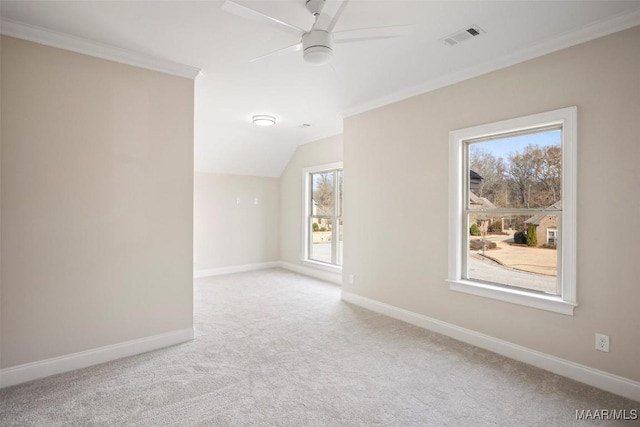 spare room with ceiling fan, light colored carpet, ornamental molding, and vaulted ceiling