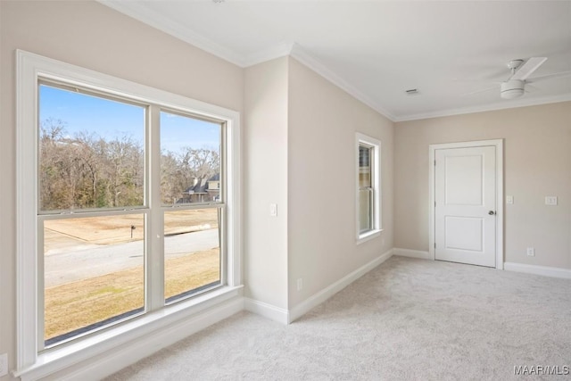 empty room with crown molding, light carpet, and ceiling fan