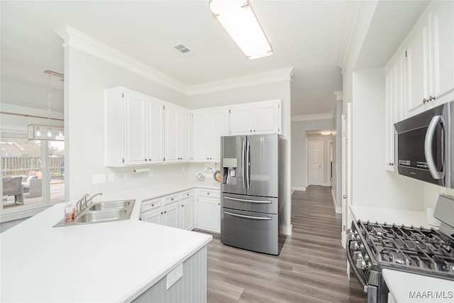 kitchen featuring sink, white cabinetry, ornamental molding, stainless steel appliances, and light hardwood / wood-style floors