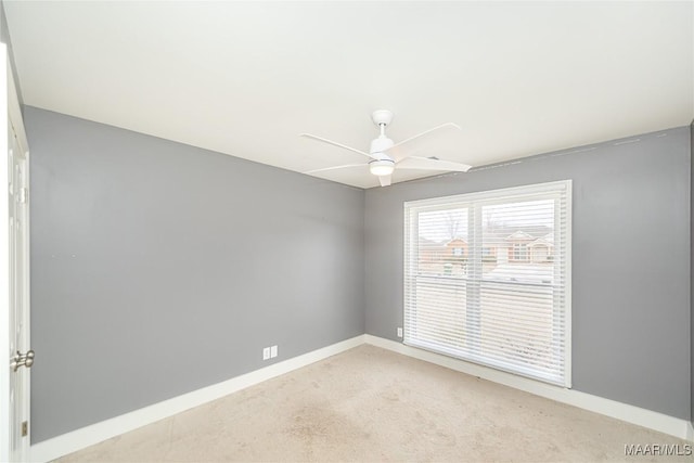 carpeted spare room featuring ceiling fan