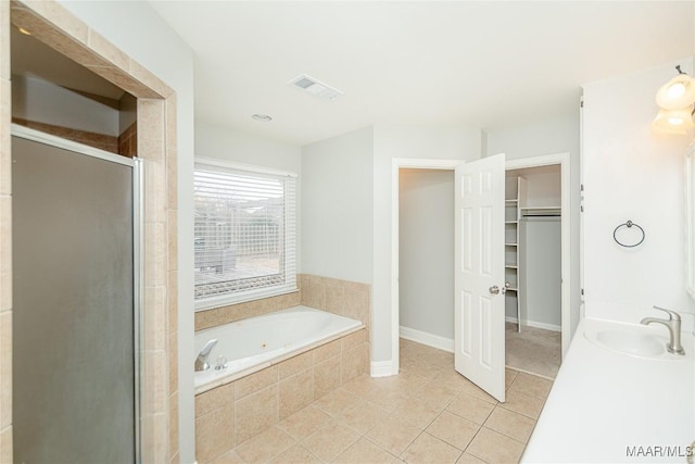 bathroom featuring tile patterned flooring, vanity, and plus walk in shower