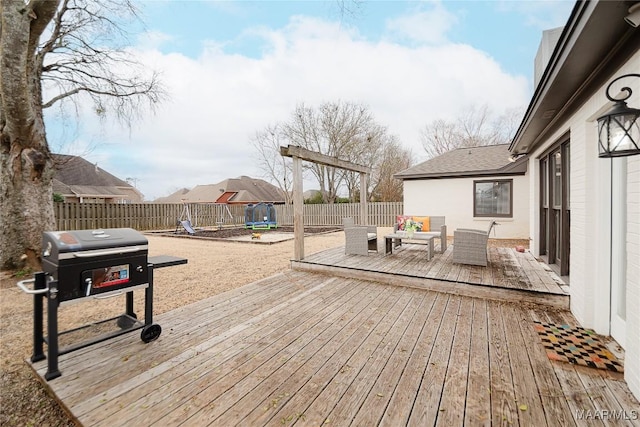 deck featuring a grill, an outdoor hangout area, and a playground