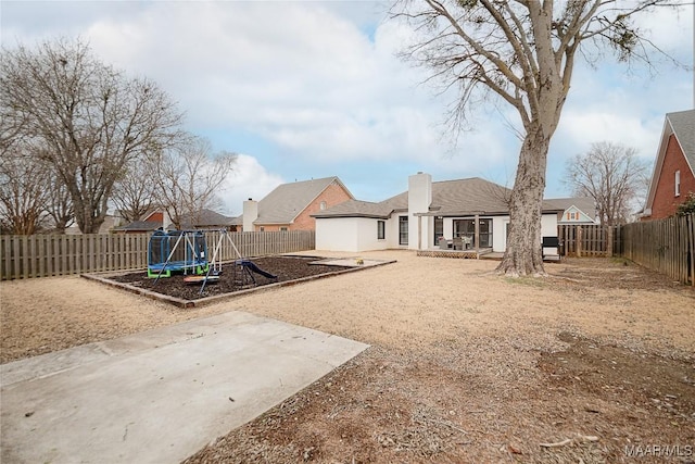 view of yard featuring a trampoline, a patio, and a playground