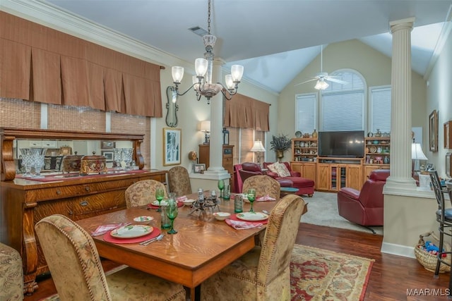 dining room featuring dark hardwood / wood-style floors, ornamental molding, ceiling fan with notable chandelier, vaulted ceiling, and ornate columns