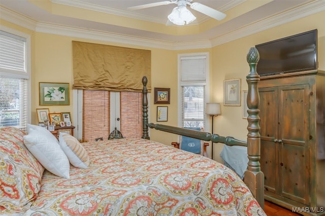 bedroom with ceiling fan, ornamental molding, and a tray ceiling