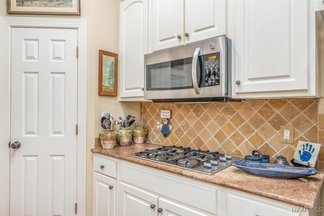 kitchen featuring white cabinetry, appliances with stainless steel finishes, and backsplash