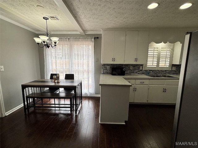 kitchen featuring dark hardwood / wood-style flooring, sink, hanging light fixtures, and white cabinets