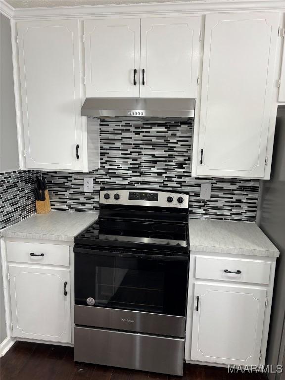 kitchen with dark hardwood / wood-style flooring, electric range, decorative backsplash, and white cabinets