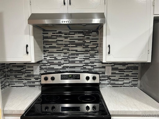 kitchen featuring ventilation hood, light countertops, stainless steel electric stove, and white cabinets