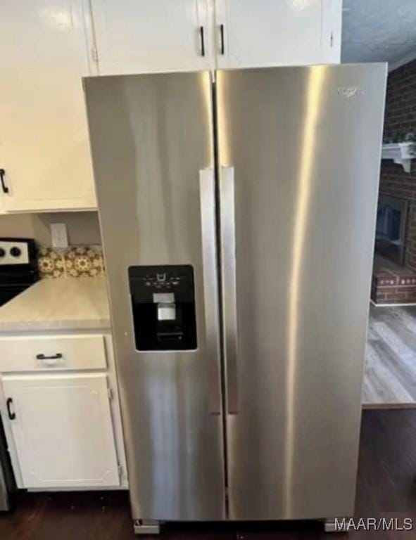 kitchen with stainless steel fridge, dark hardwood / wood-style floors, white cabinets, and range