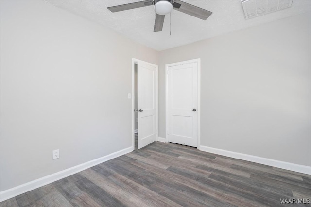 empty room with dark hardwood / wood-style floors, a textured ceiling, and ceiling fan