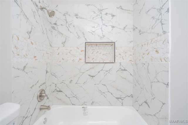 bathroom featuring toilet and tiled shower / bath combo