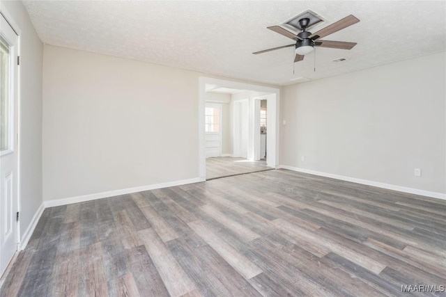 empty room featuring ceiling fan, wood-type flooring, and a textured ceiling