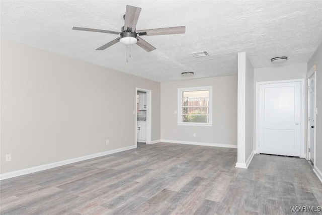 spare room with ceiling fan, hardwood / wood-style flooring, and a textured ceiling