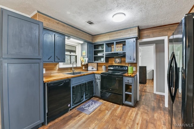 kitchen featuring blue cabinetry, sink, a textured ceiling, hardwood / wood-style floors, and black appliances