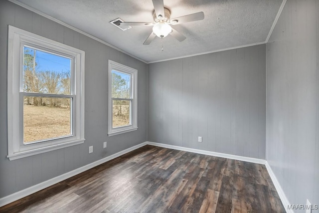 spare room with crown molding, ceiling fan, dark wood-type flooring, and a textured ceiling