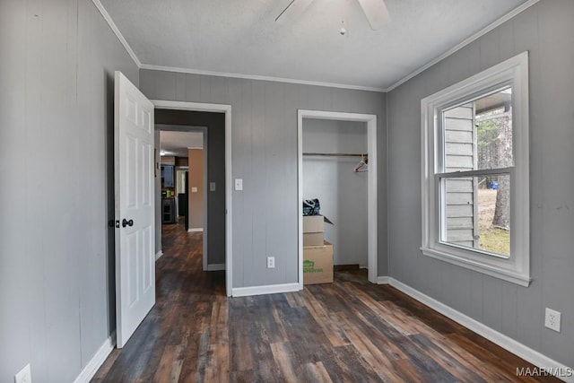 unfurnished bedroom featuring crown molding, dark hardwood / wood-style floors, ceiling fan, and a closet