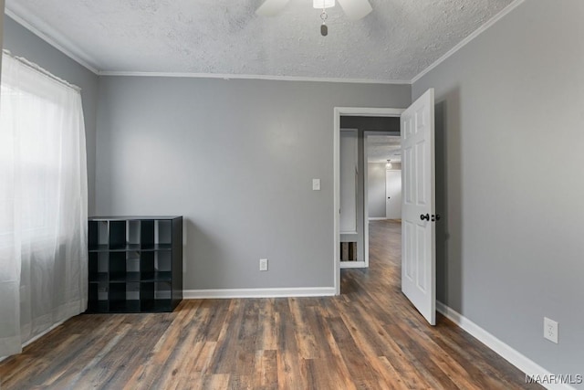 unfurnished room featuring dark hardwood / wood-style flooring, ceiling fan, crown molding, and a textured ceiling