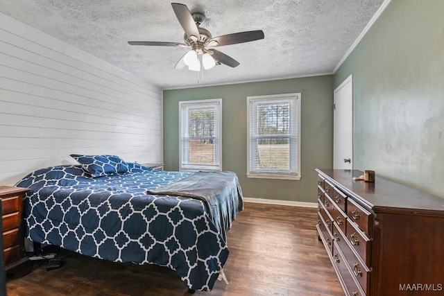 bedroom with crown molding, a textured ceiling, wooden walls, dark hardwood / wood-style flooring, and ceiling fan