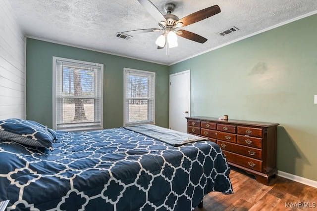 bedroom with crown molding, ceiling fan, dark hardwood / wood-style floors, and a textured ceiling