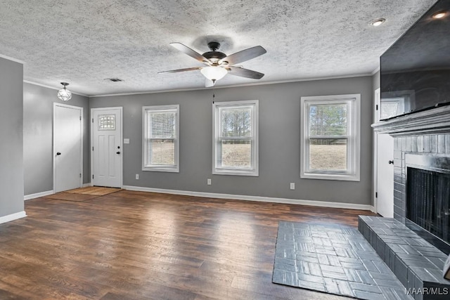 unfurnished living room with crown molding, a brick fireplace, a textured ceiling, dark hardwood / wood-style flooring, and ceiling fan