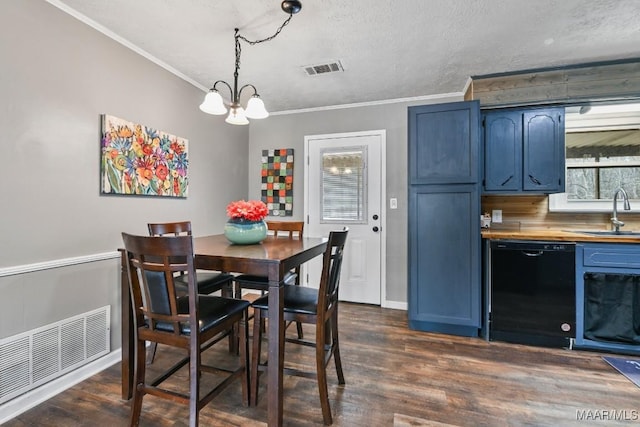 dining area featuring crown molding, a healthy amount of sunlight, sink, and dark hardwood / wood-style flooring