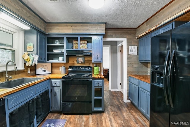 kitchen with blue cabinetry, butcher block counters, sink, and black appliances