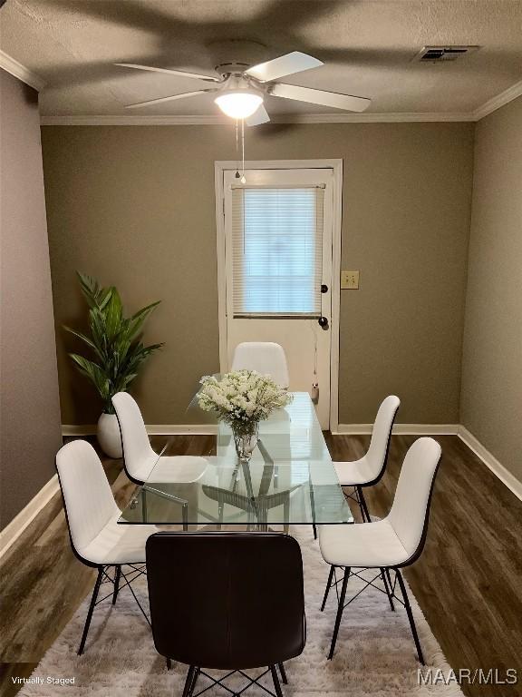 dining space with crown molding, hardwood / wood-style floors, ceiling fan, and a textured ceiling