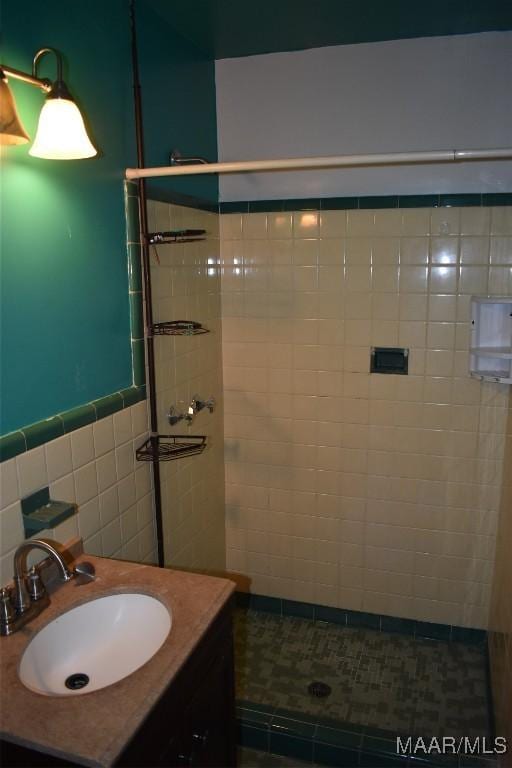 bathroom featuring tile walls, vanity, and tiled shower